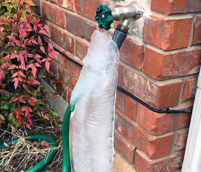a ruptured pipe covered in frozen water